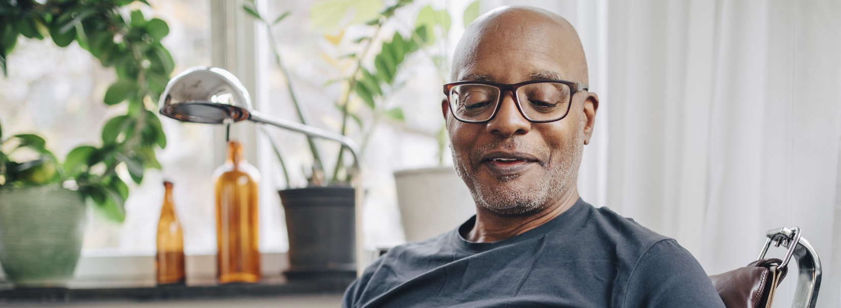 Man sitting on a chair with his dog looking at his phone