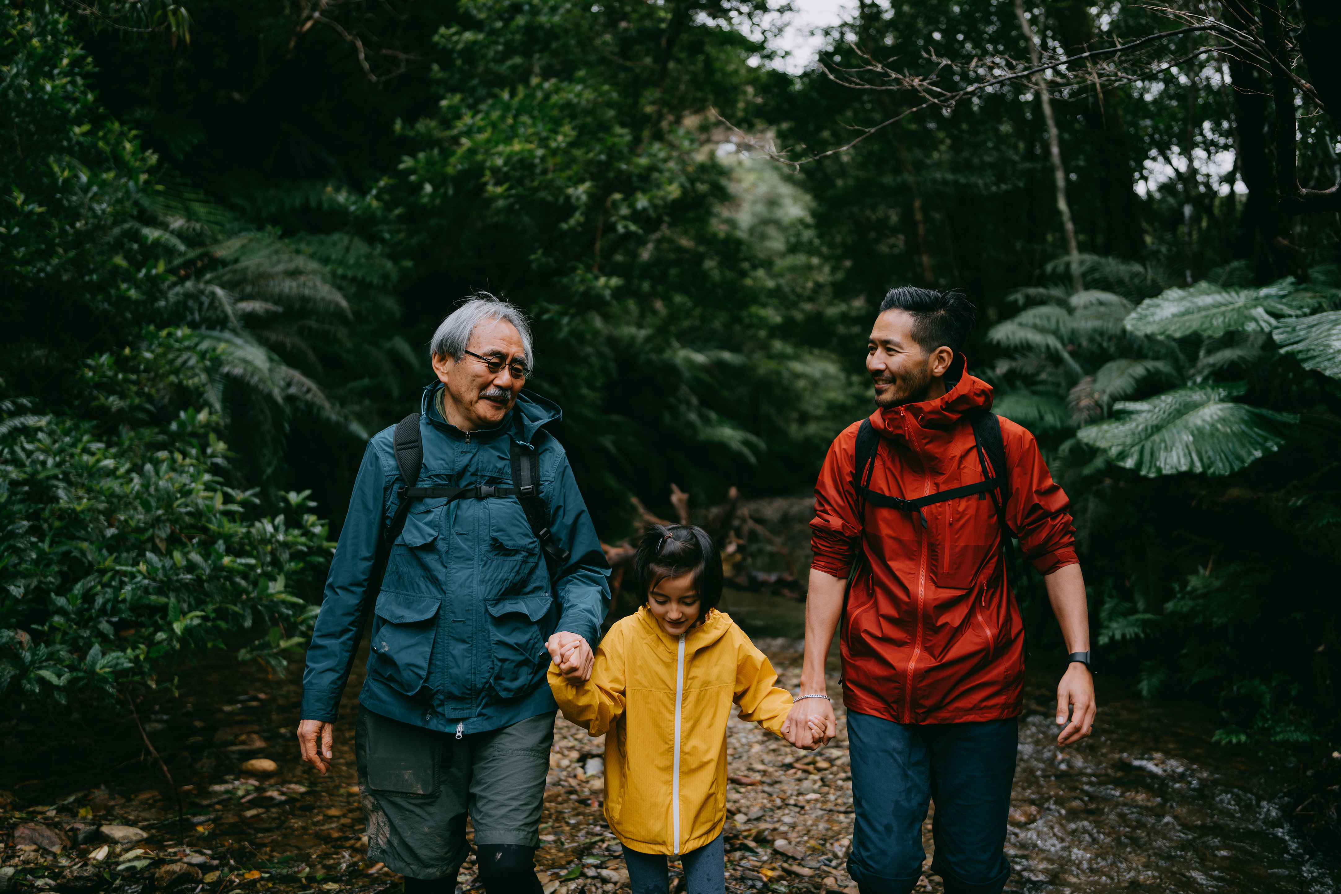 Two males and a boy walking through the woods