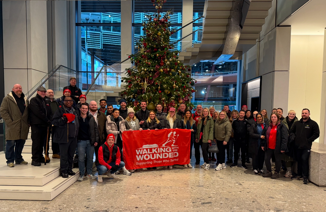 SPW employees standing in front of a Christmas tree in an office