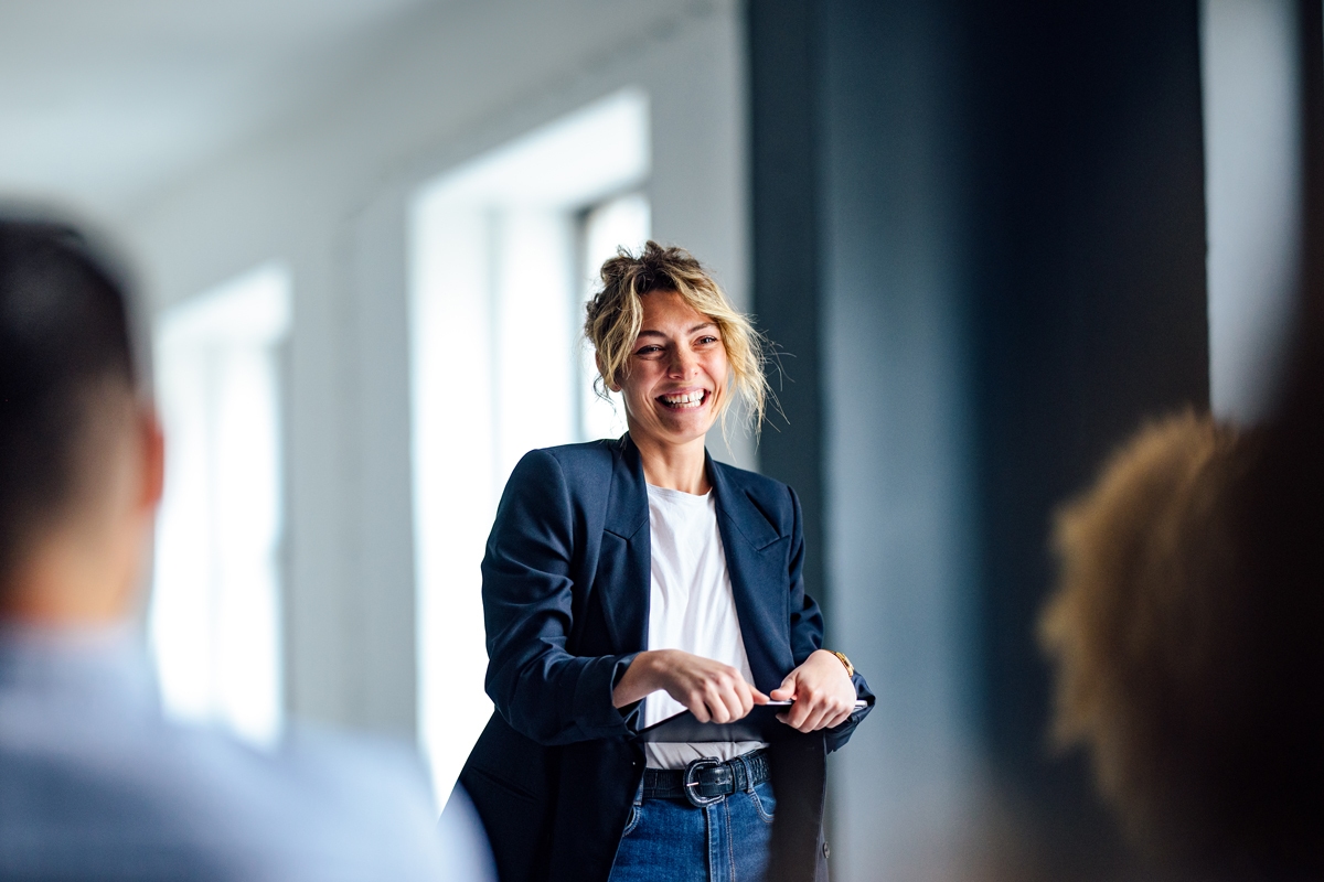 Female holding an iPad talking to a group of people