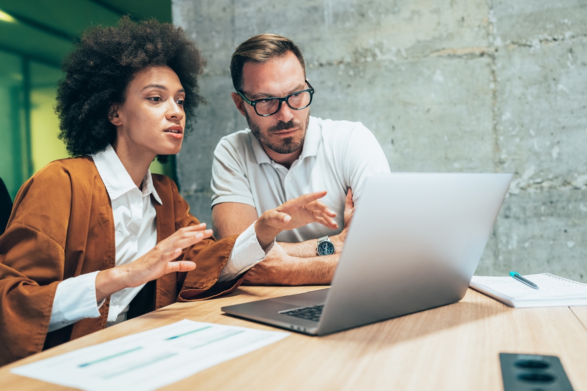 Male and female looking at laptop in discussion