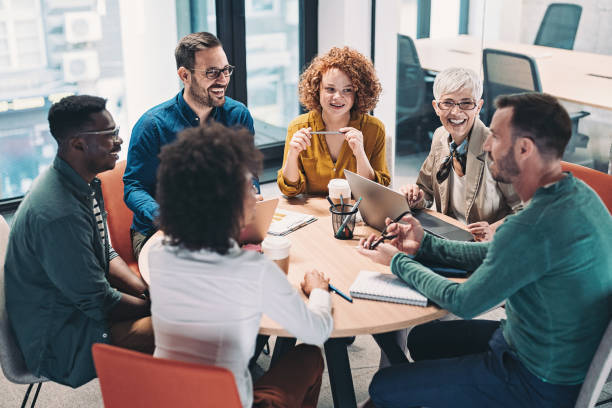 Group of colleagues sitting round a table laughing