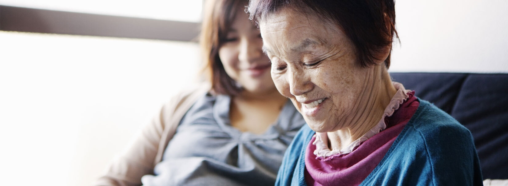 mother and daughter sitting down on the sofa