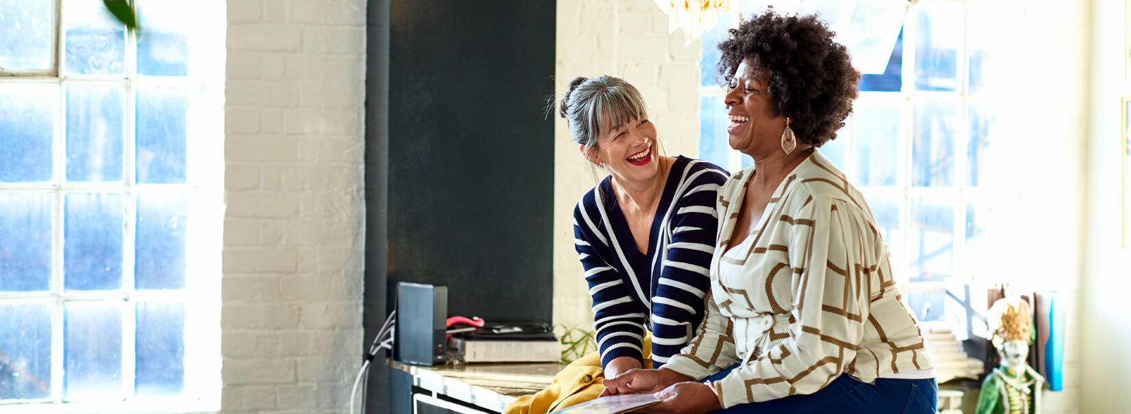 Two women sitting on the kitchen counter