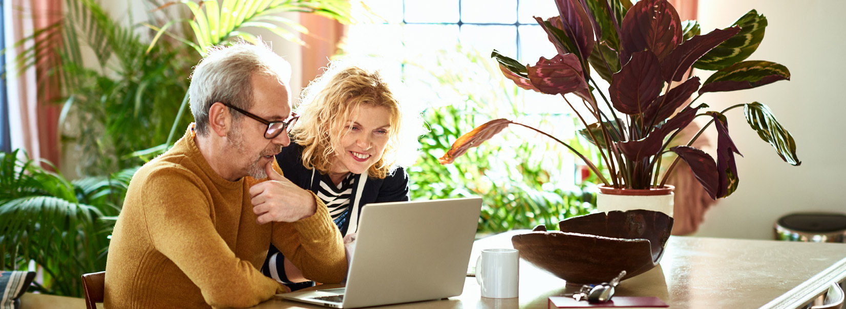 excited women and man looking at a laptop
