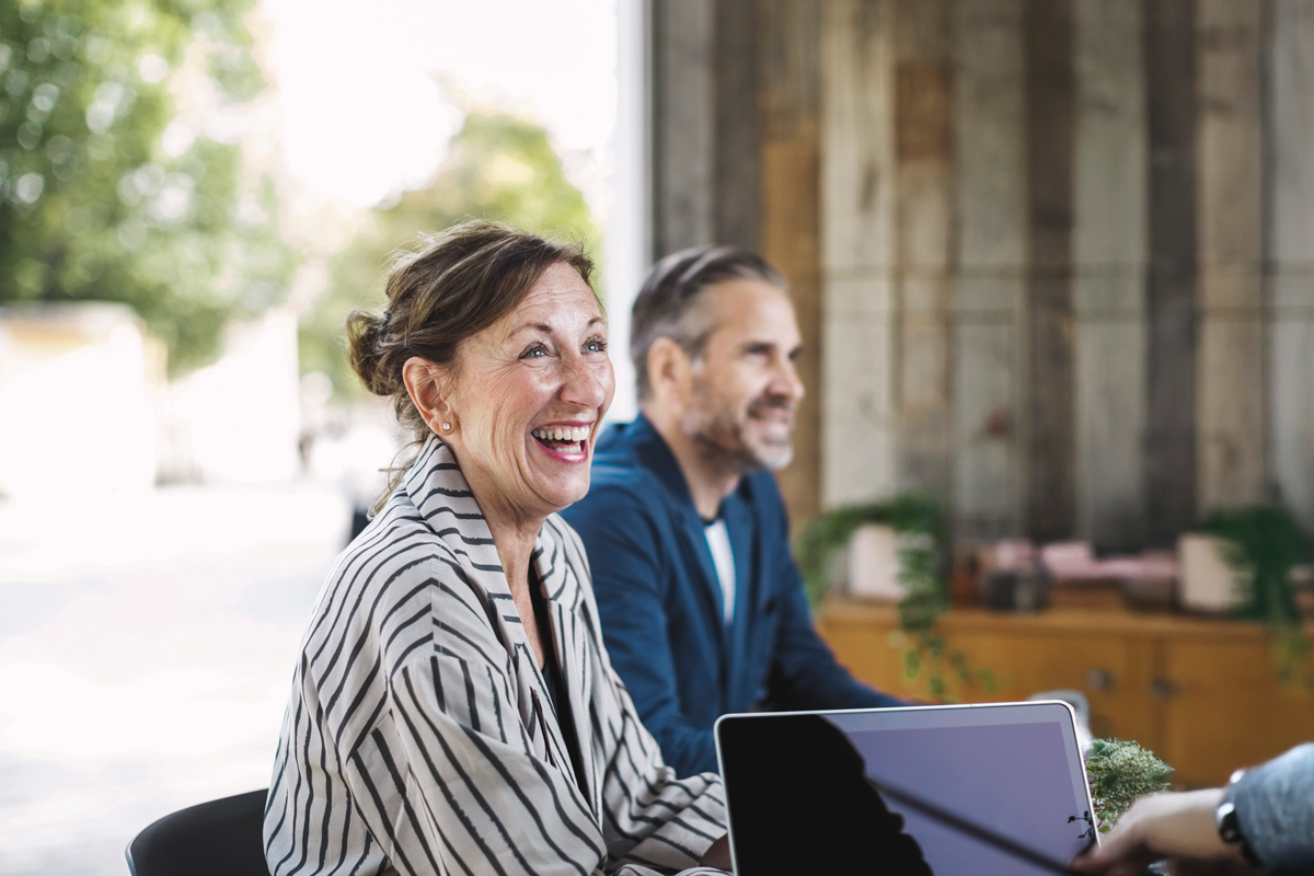 Women and man smiling sitting at table