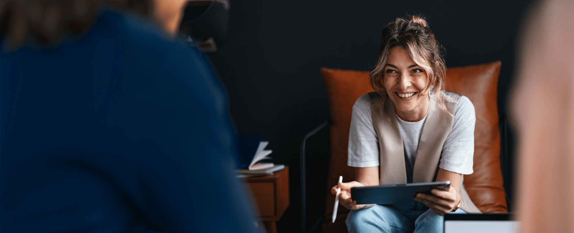 Woman holding a tablet talking to a client