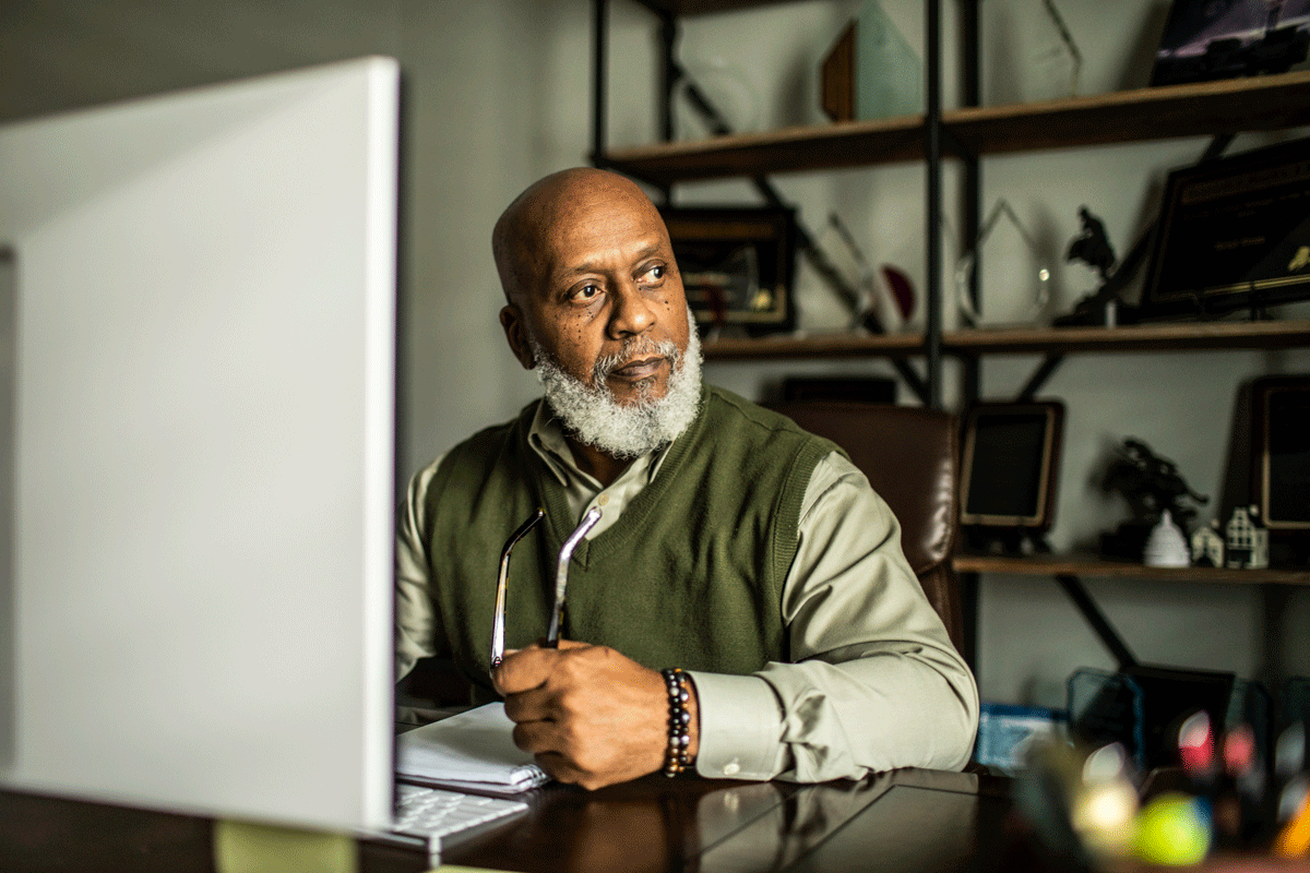 Senior man at desktop computer in home